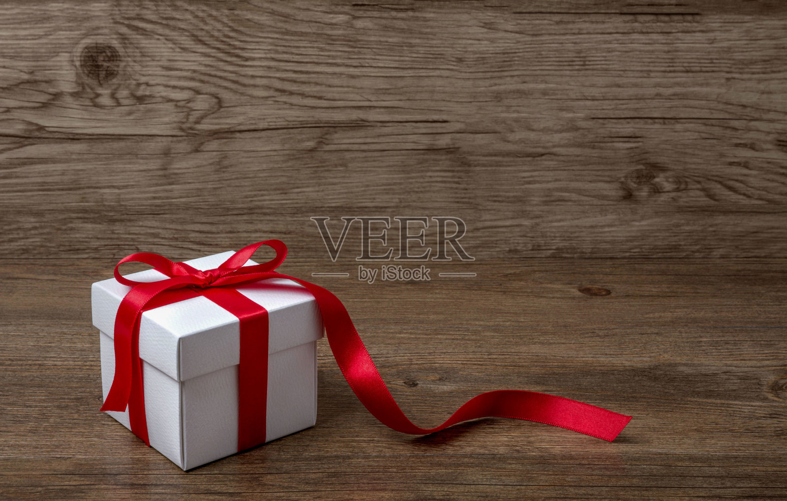 礼盒与红色蝴蝶结在质朴的桌子上，圣诞节或照片摄影图片