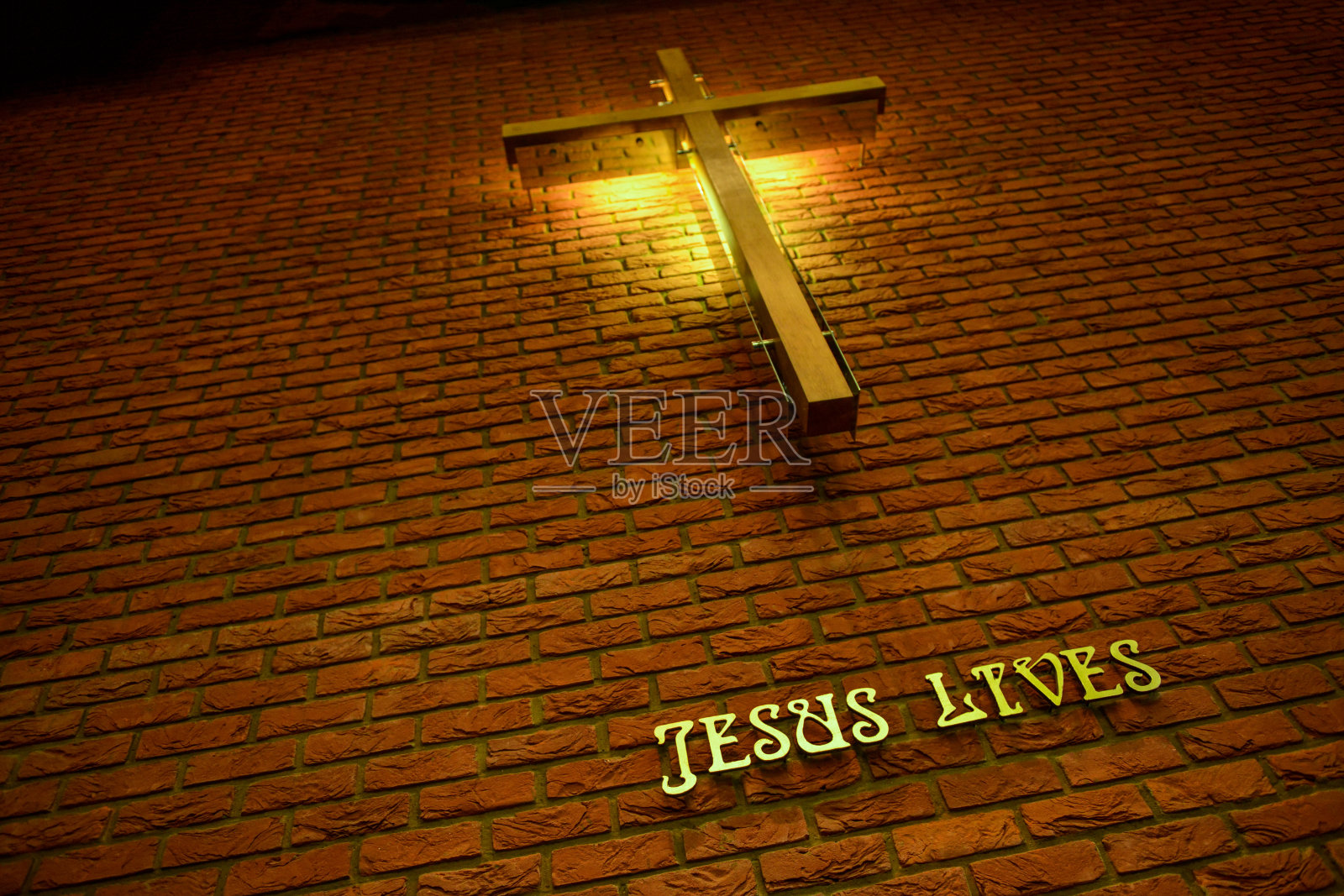 十字架上写着耶稣住在砖墙上照片摄影图片