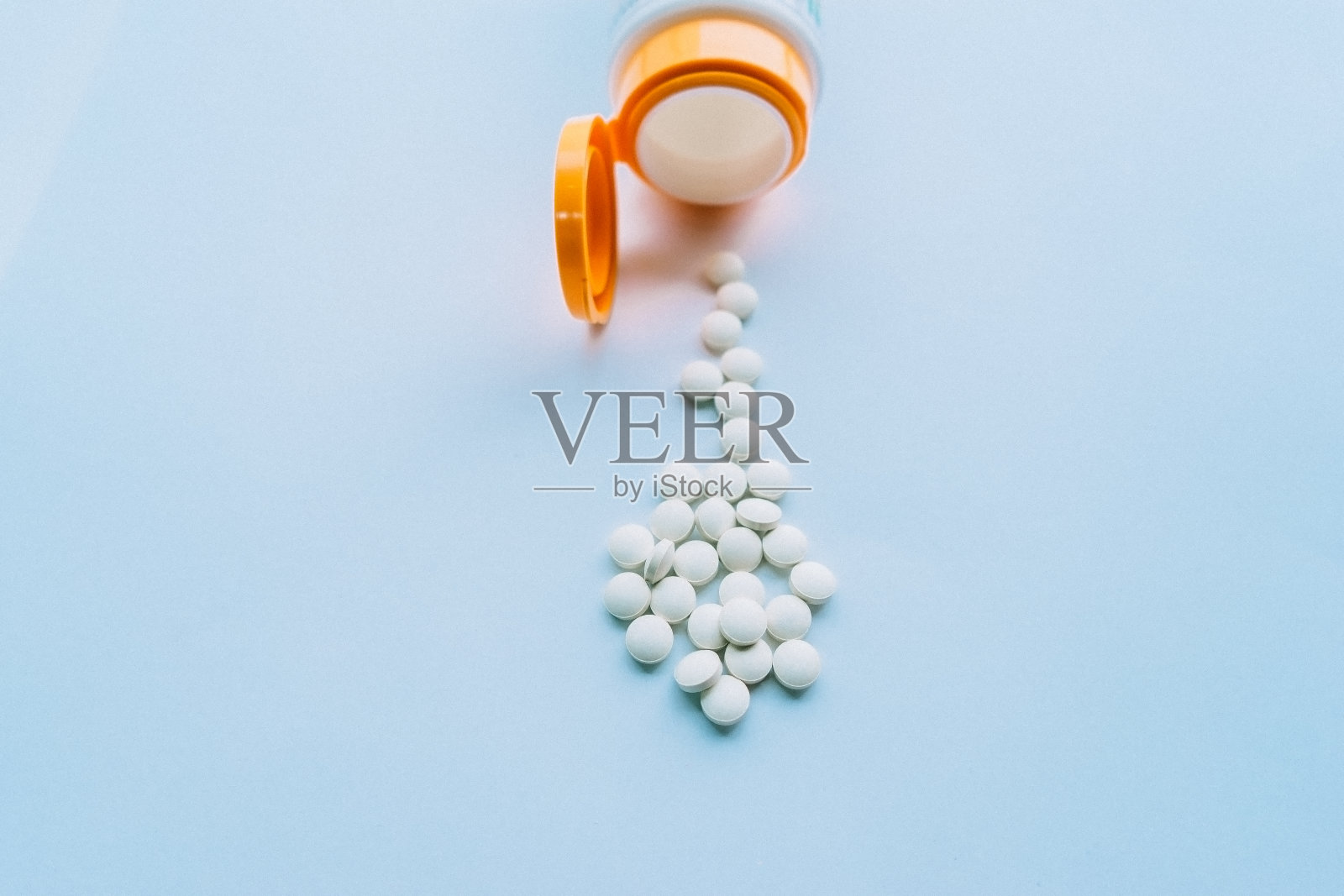 药丸从药瓶里出来，白色的背景照片摄影图片