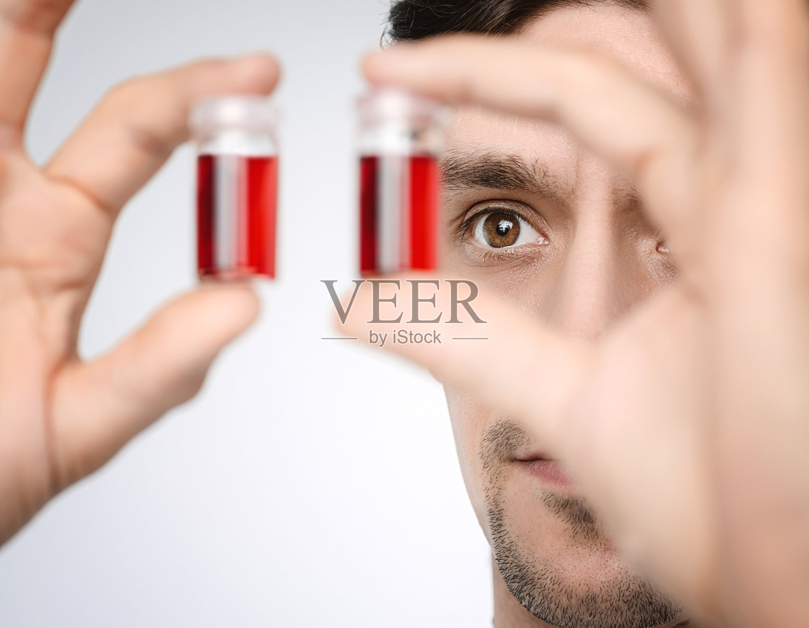 年轻的男性医生或研究人员拿着液体样本照片摄影图片