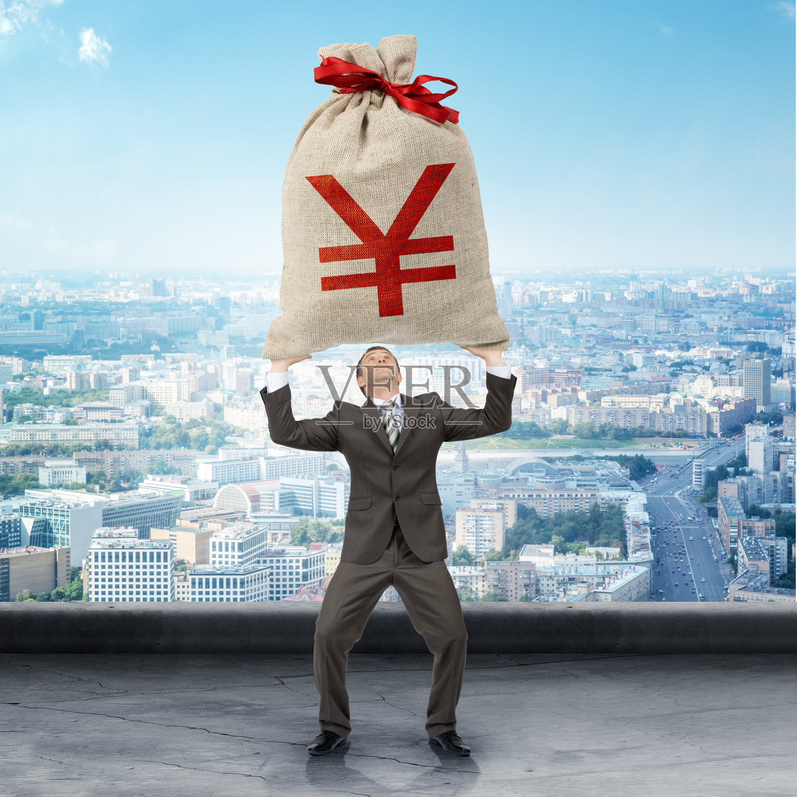 商人拿着一个有日元标志的大钱袋照片摄影图片