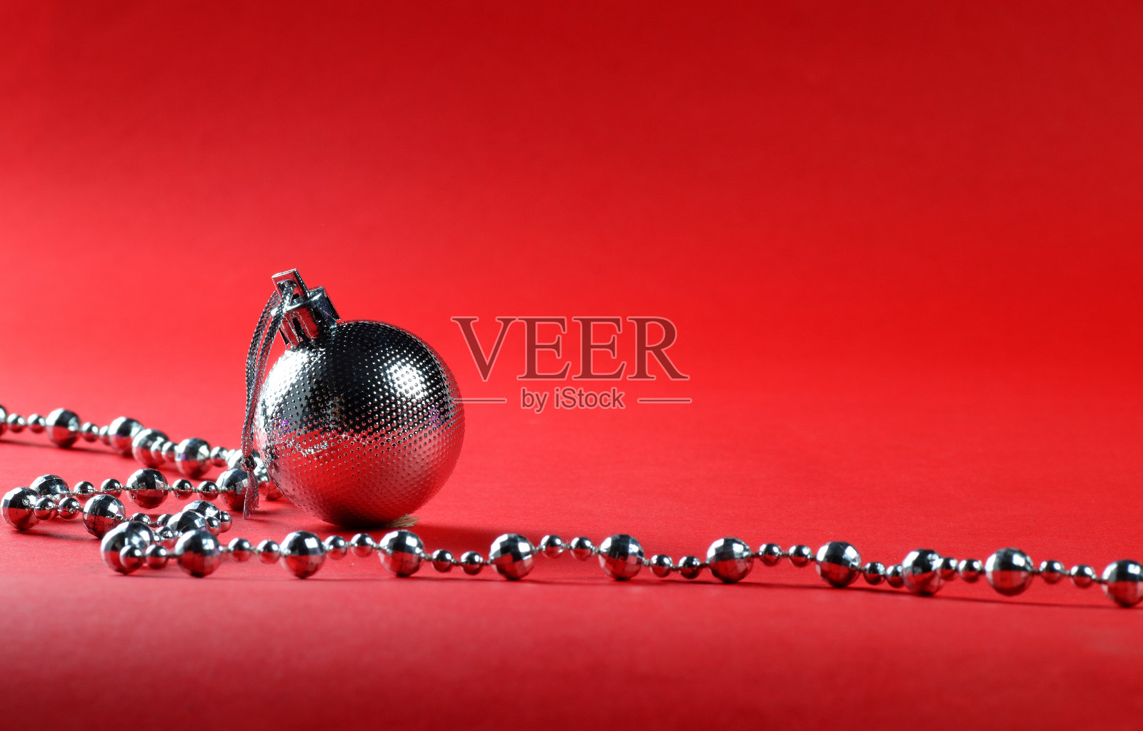 银色圣诞球与装饰品在红色的背景。照片摄影图片