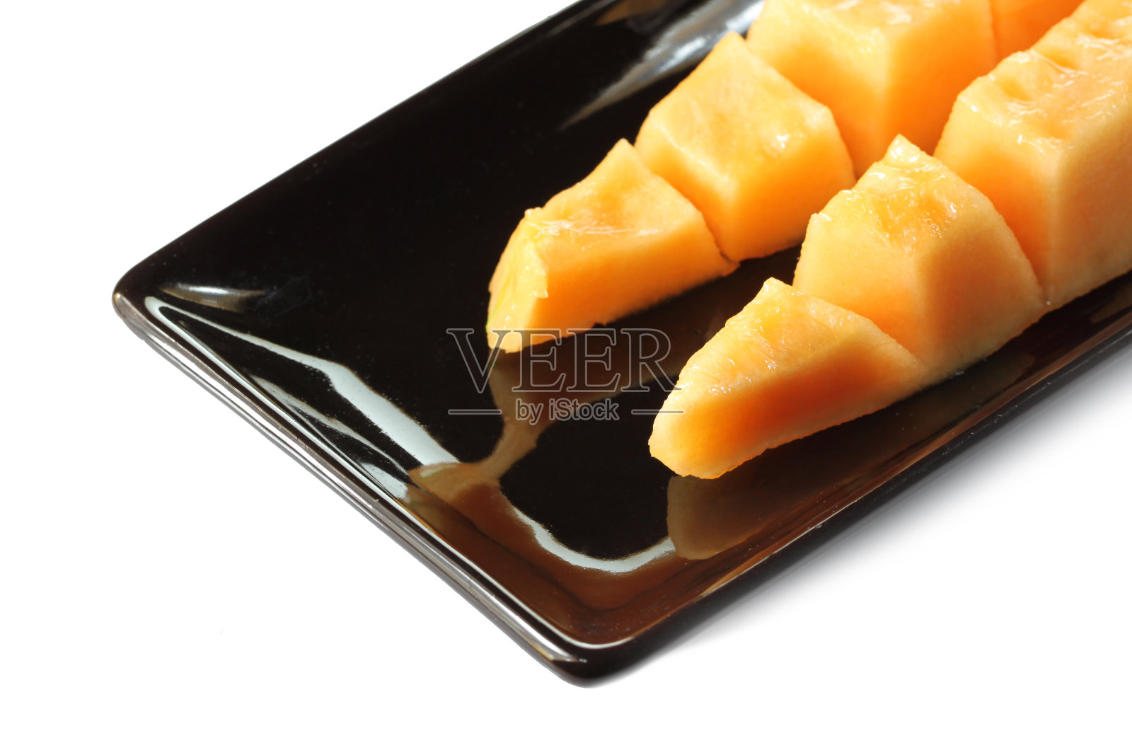 黑盘中的哈密瓜果肉切片照片摄影图片