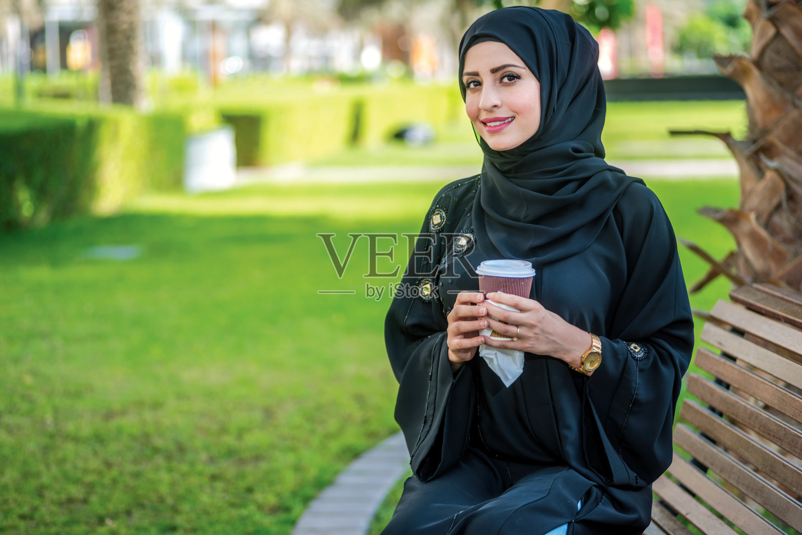 商业与阿拉伯咖啡：戴着头巾的阿拉伯女商人照片摄影图片