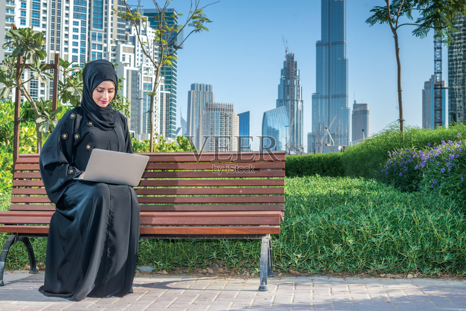 阿联酋商务：戴着头巾的阿拉伯女商人在笔记本电脑前工作照片摄影图片