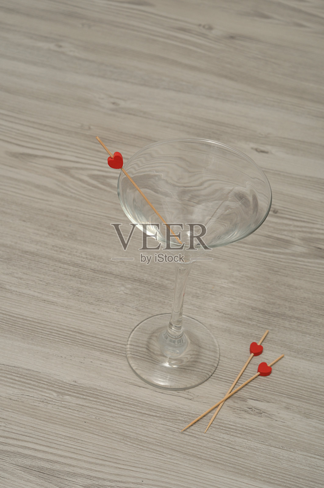 马提尼酒杯，上面有三根饰有红心的木棍照片摄影图片