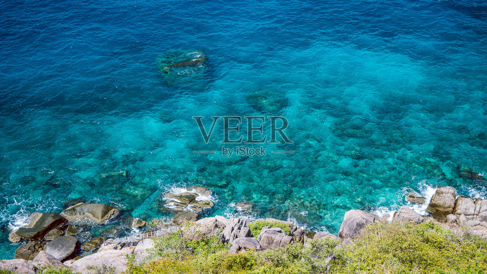 泰国南园岛西侧清澈的蓝水拍打着岩石照片摄影图片