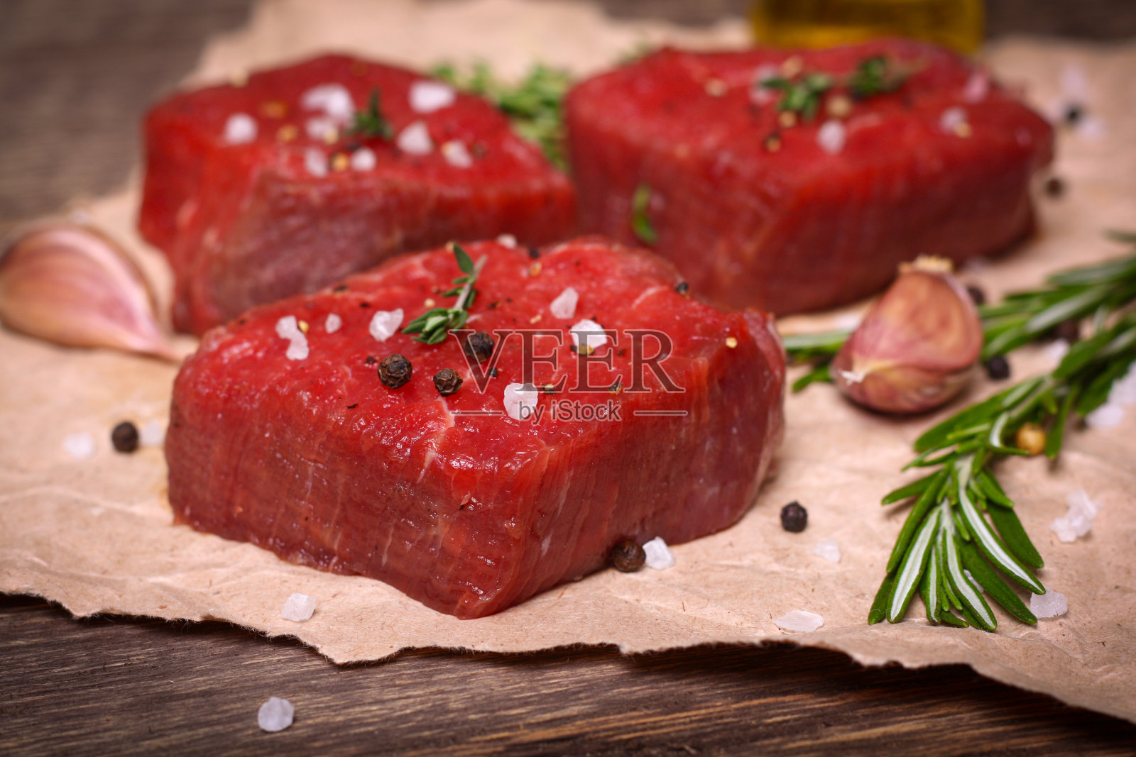 生牛排配迷迭香、百里香和大蒜照片摄影图片