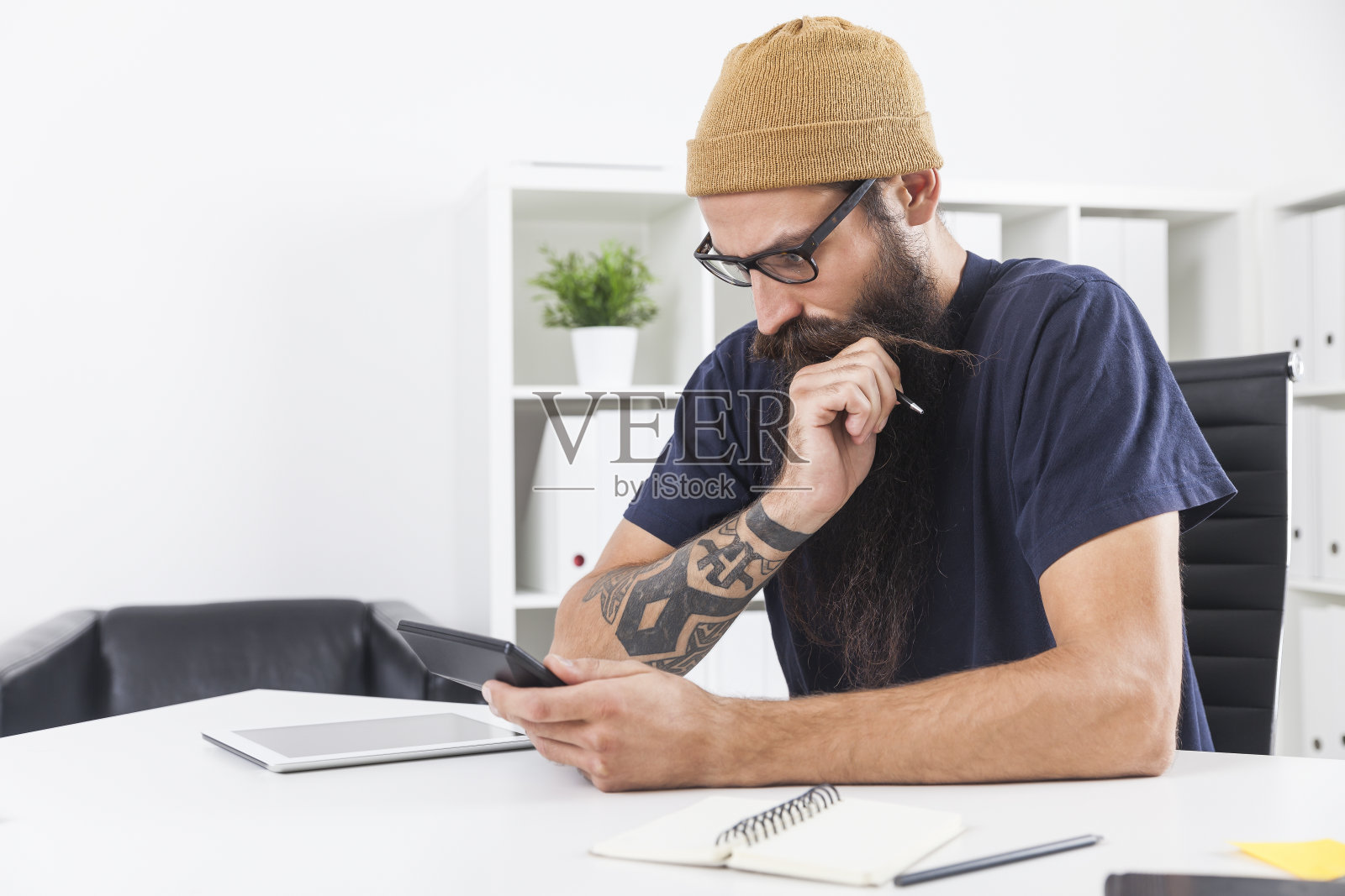 戴着便帽的商人正看着计算器照片摄影图片