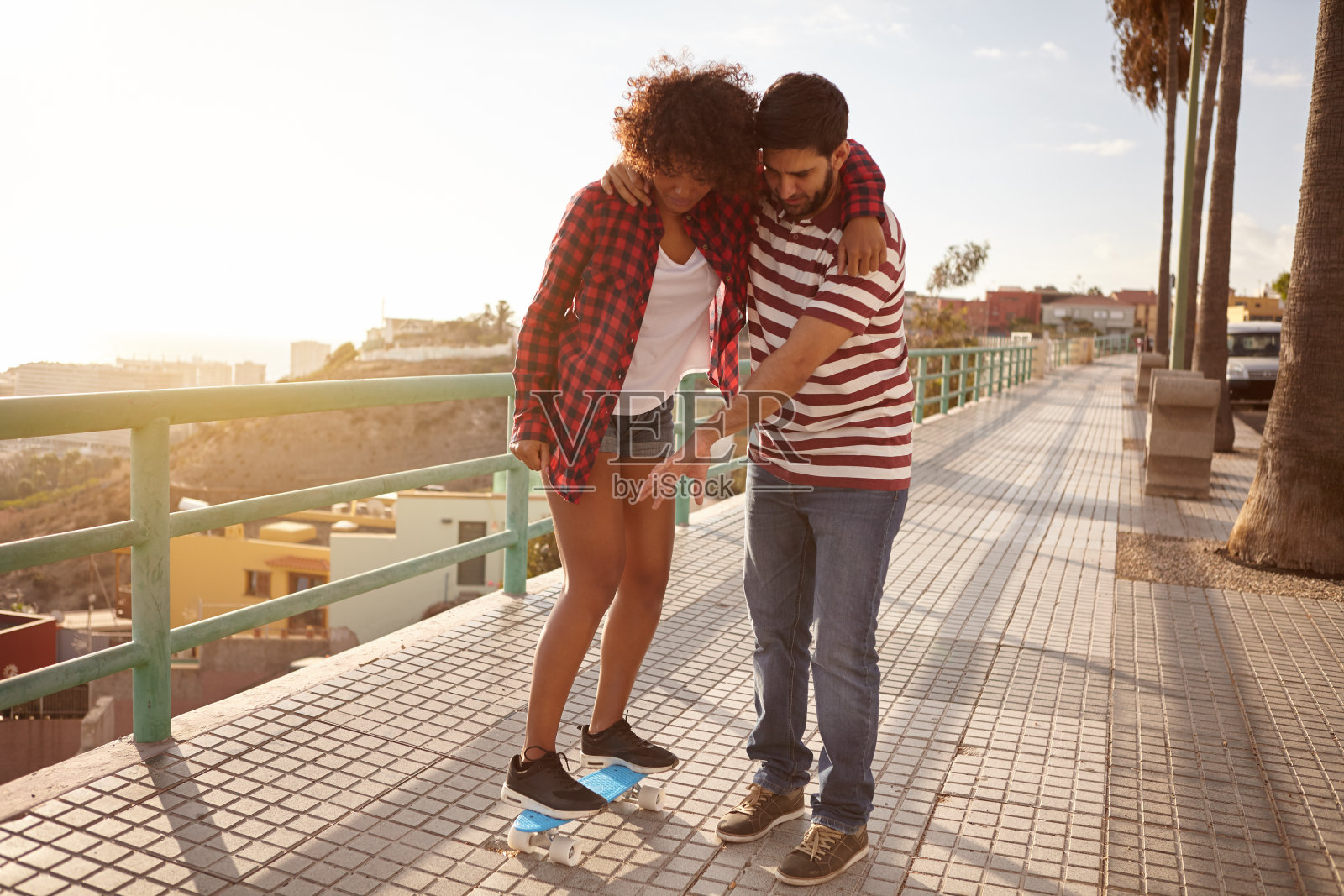 男孩教女孩如何玩滑板照片摄影图片
