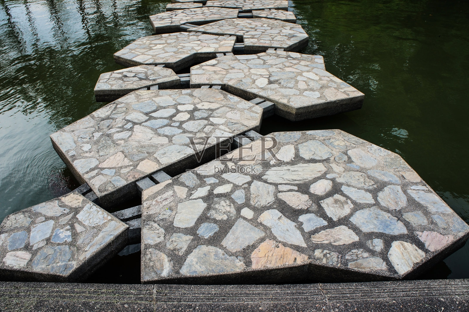 横跨池塘的小路上的装饰石头照片摄影图片