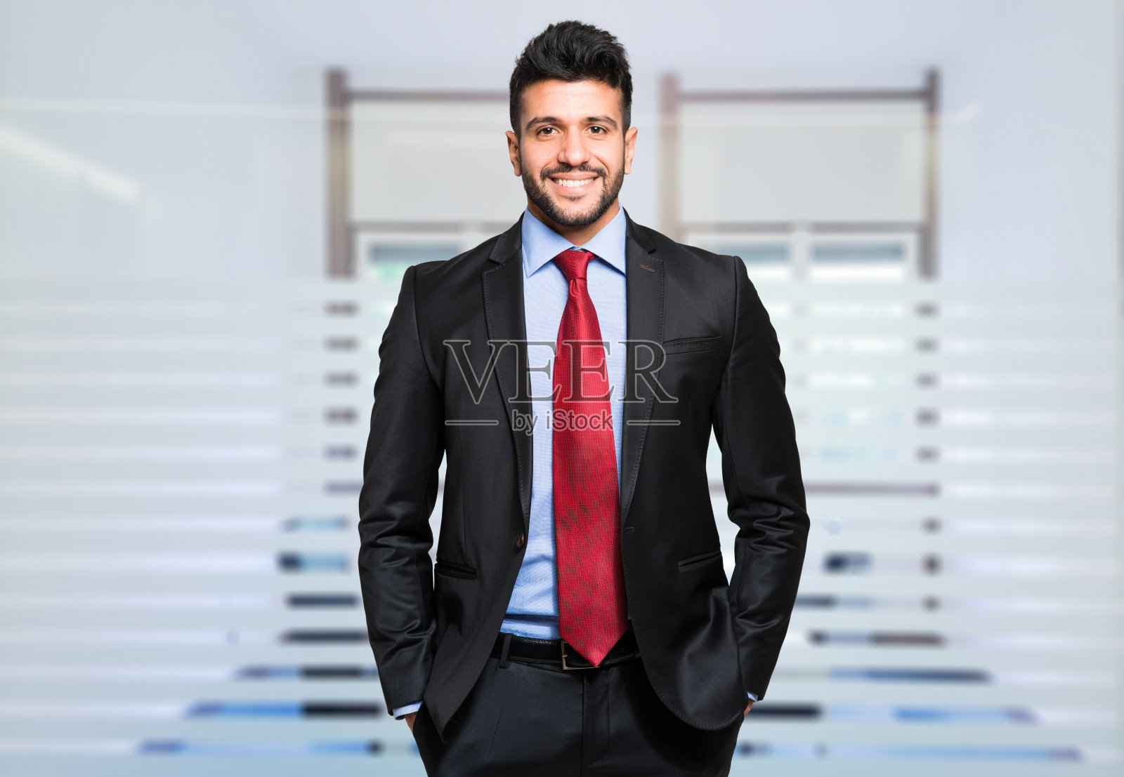 一个微笑的年轻商人在他的办公室里的肖像照片摄影图片