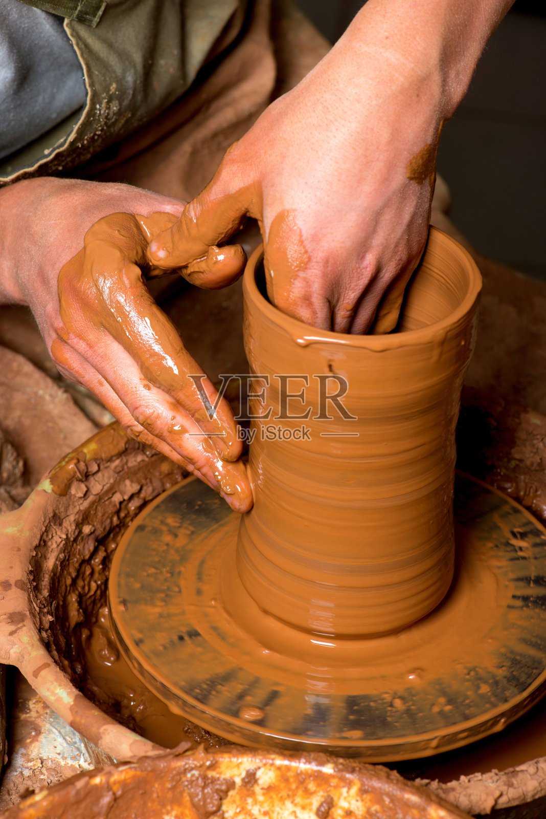 陶工的双手，创造了一个陶罐照片摄影图片