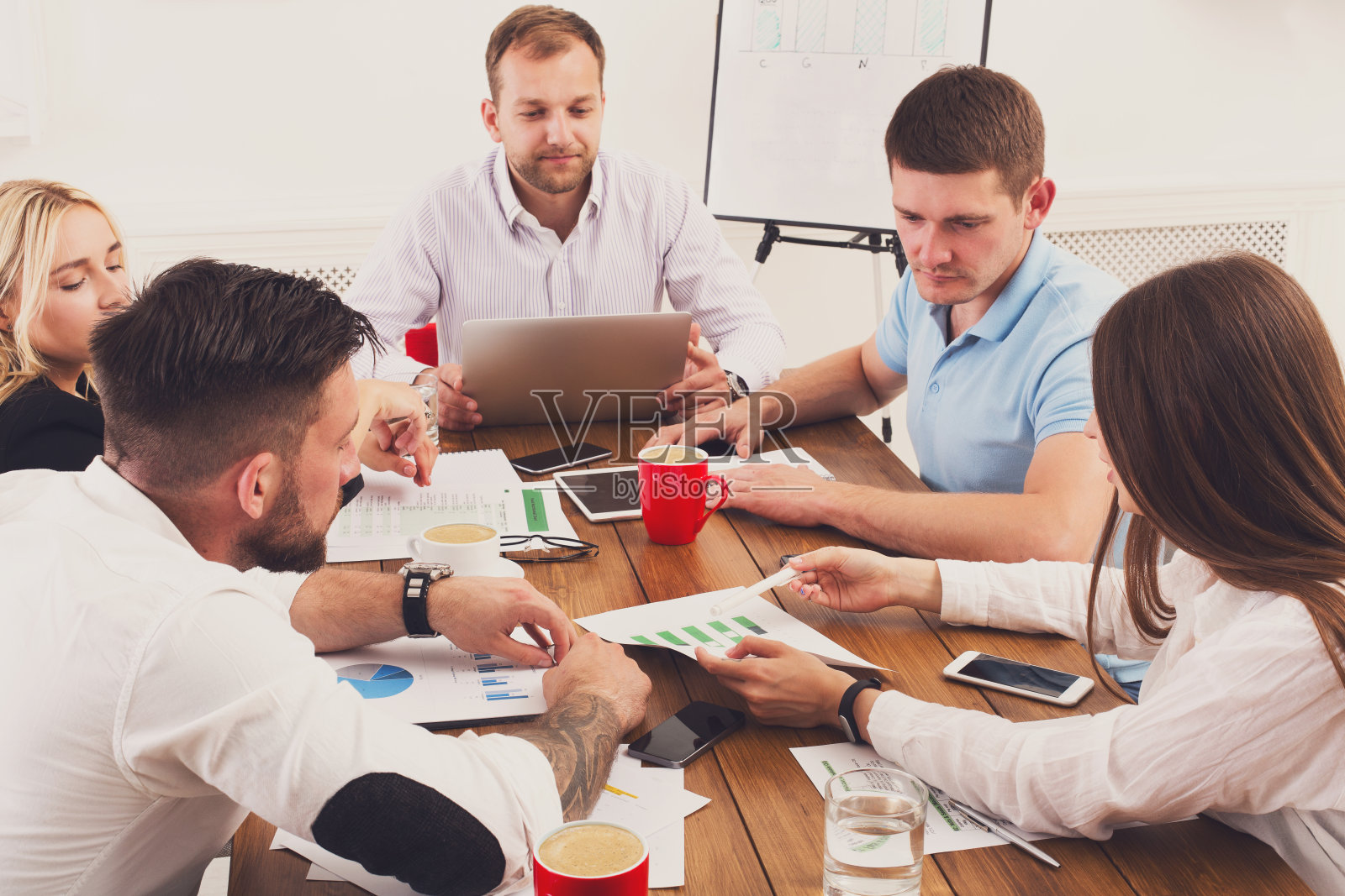 商务会议。在现代办公室里的年轻时髦的商人和女人们照片摄影图片