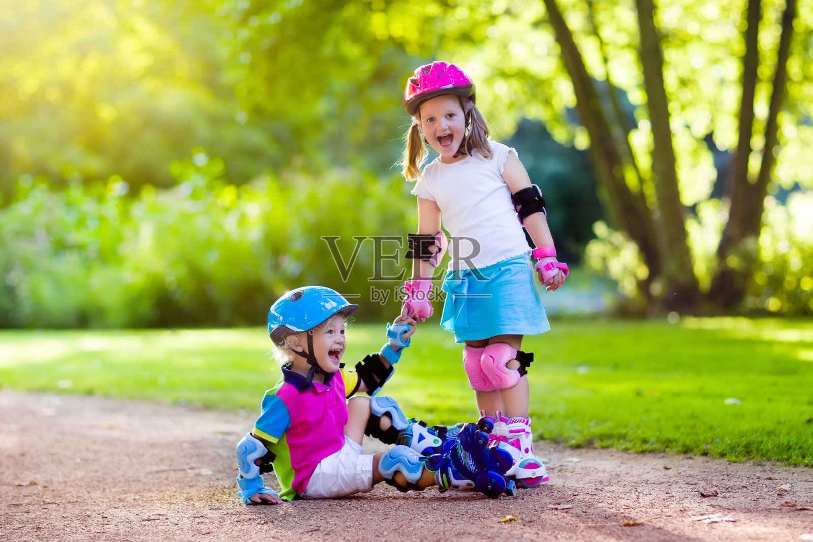 孩子们在夏季公园滑旱冰照片摄影图片