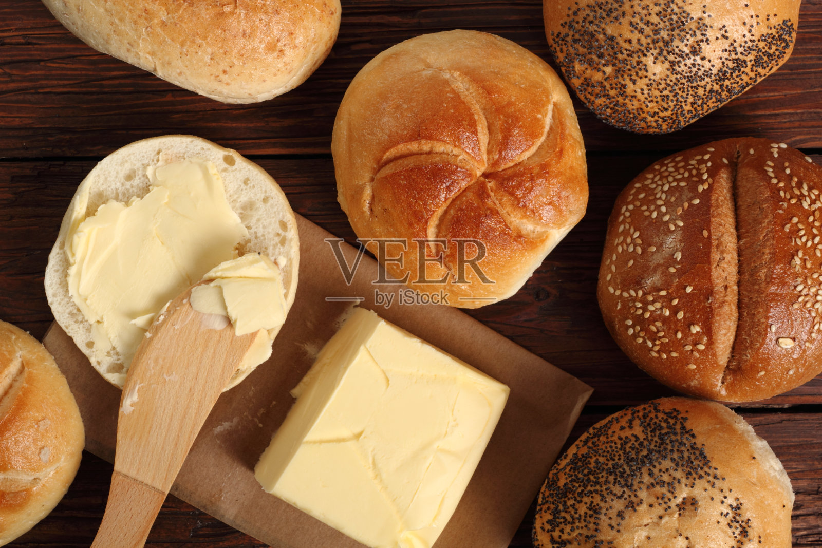 在面包卷上涂黄油。直接上图。照片摄影图片