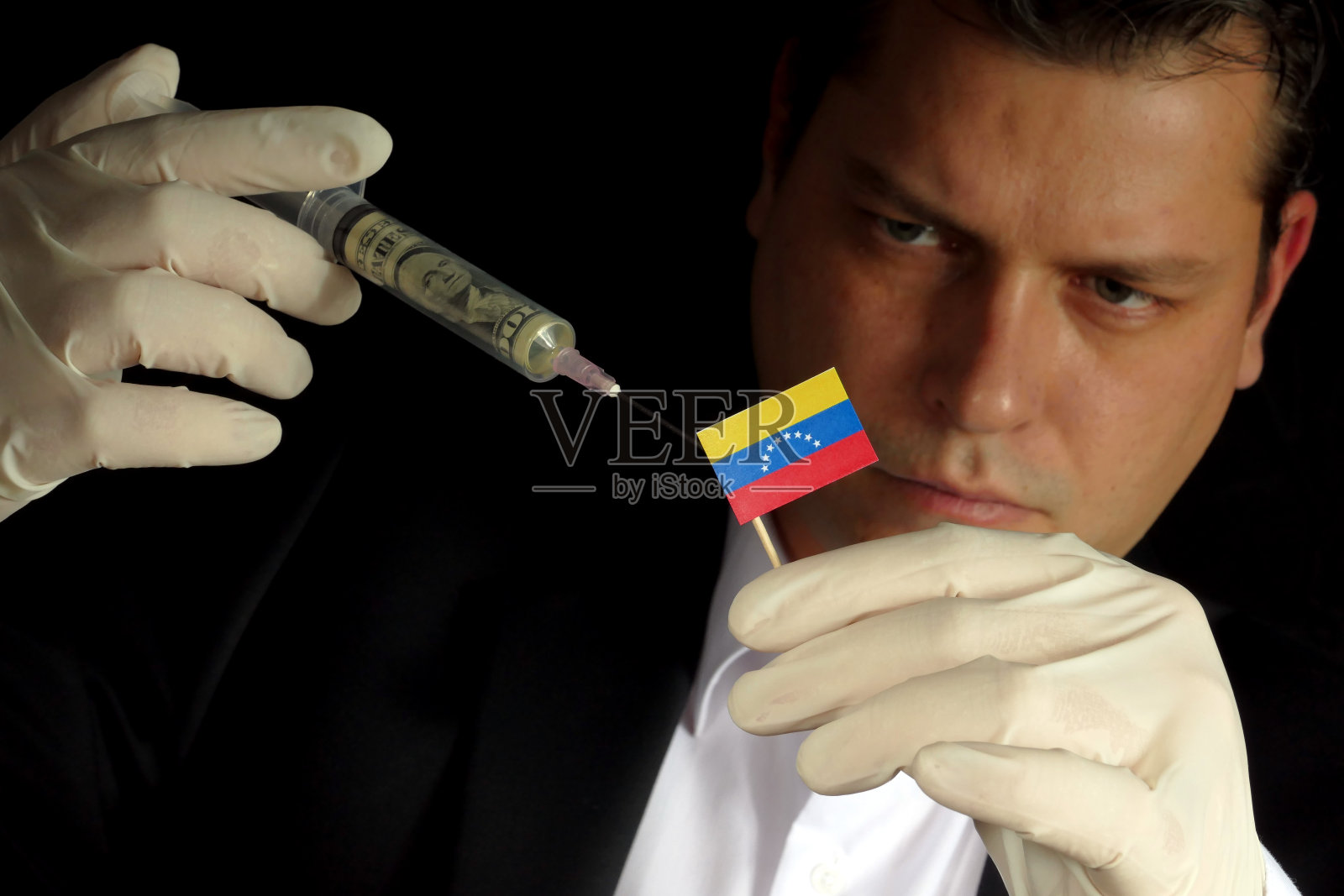 年轻的商人给委内瑞拉国旗注入资金，孤立的黑人背景照片摄影图片