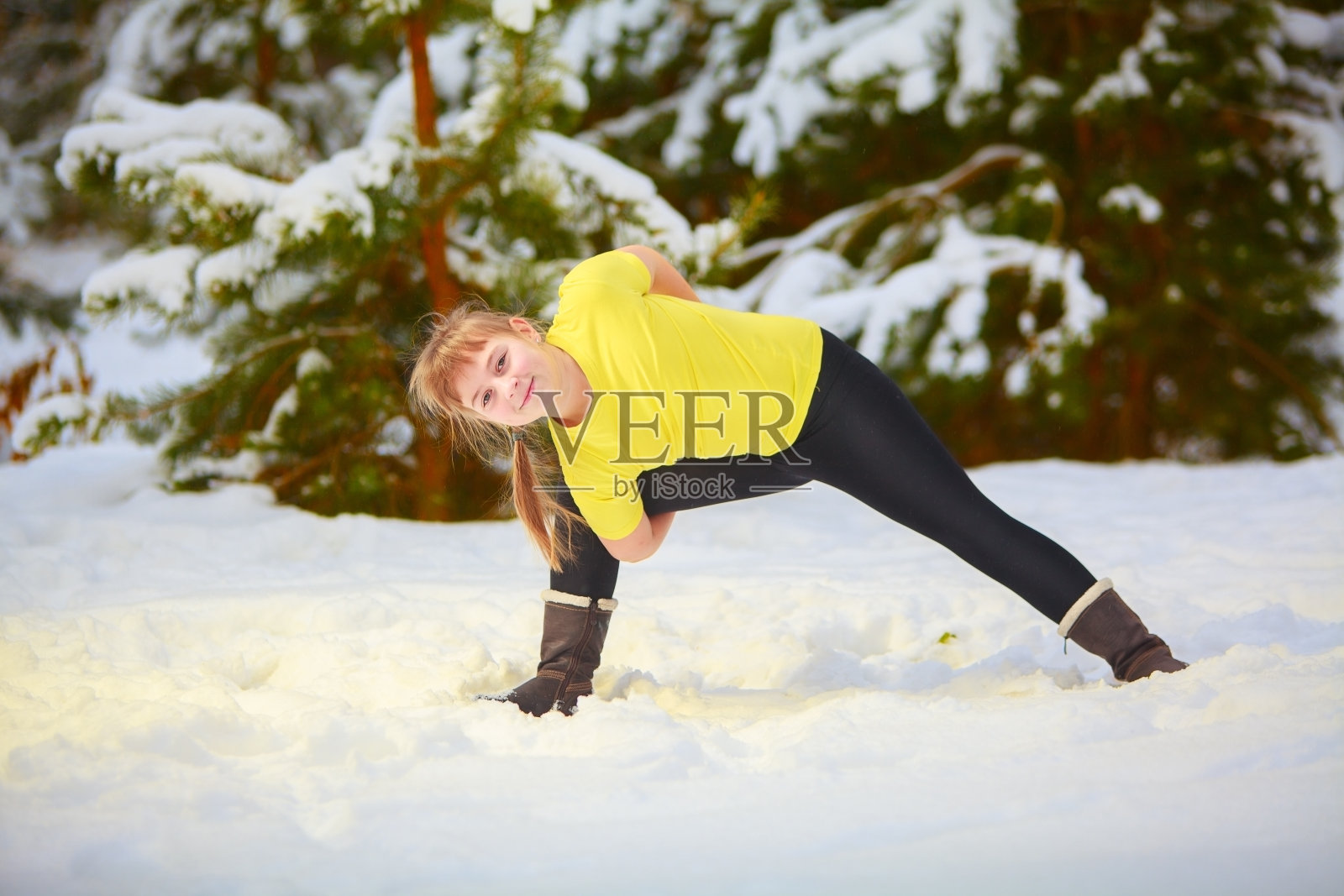 一个美丽的女人在雪地里做瑜伽照片摄影图片