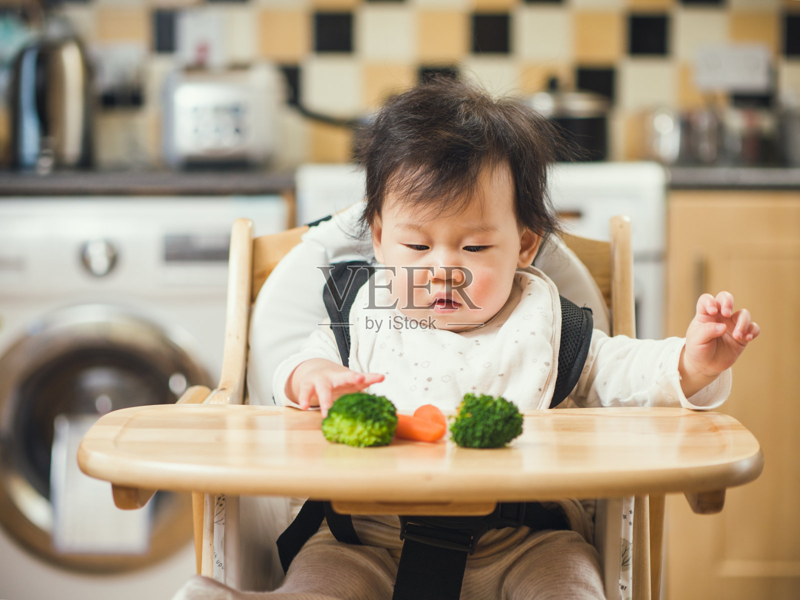 女婴第一次在家吃西兰花、胡萝卜等蔬菜照片摄影图片