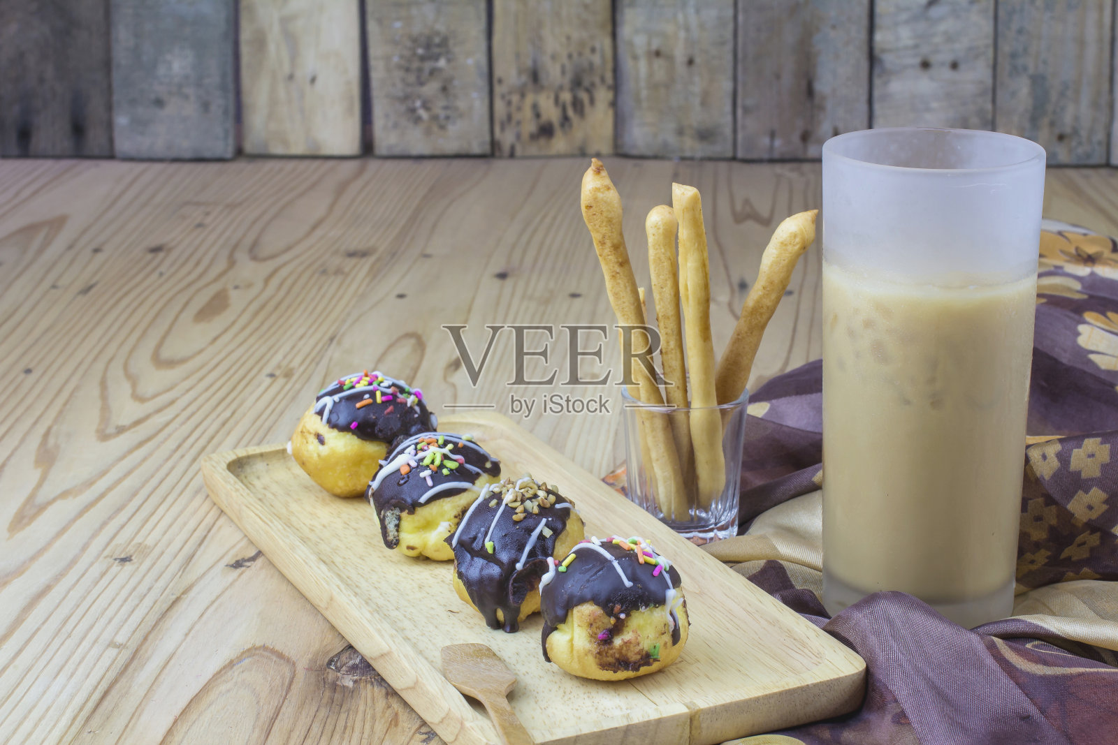 甜甜圈和冰咖啡，背景是木头。照片摄影图片