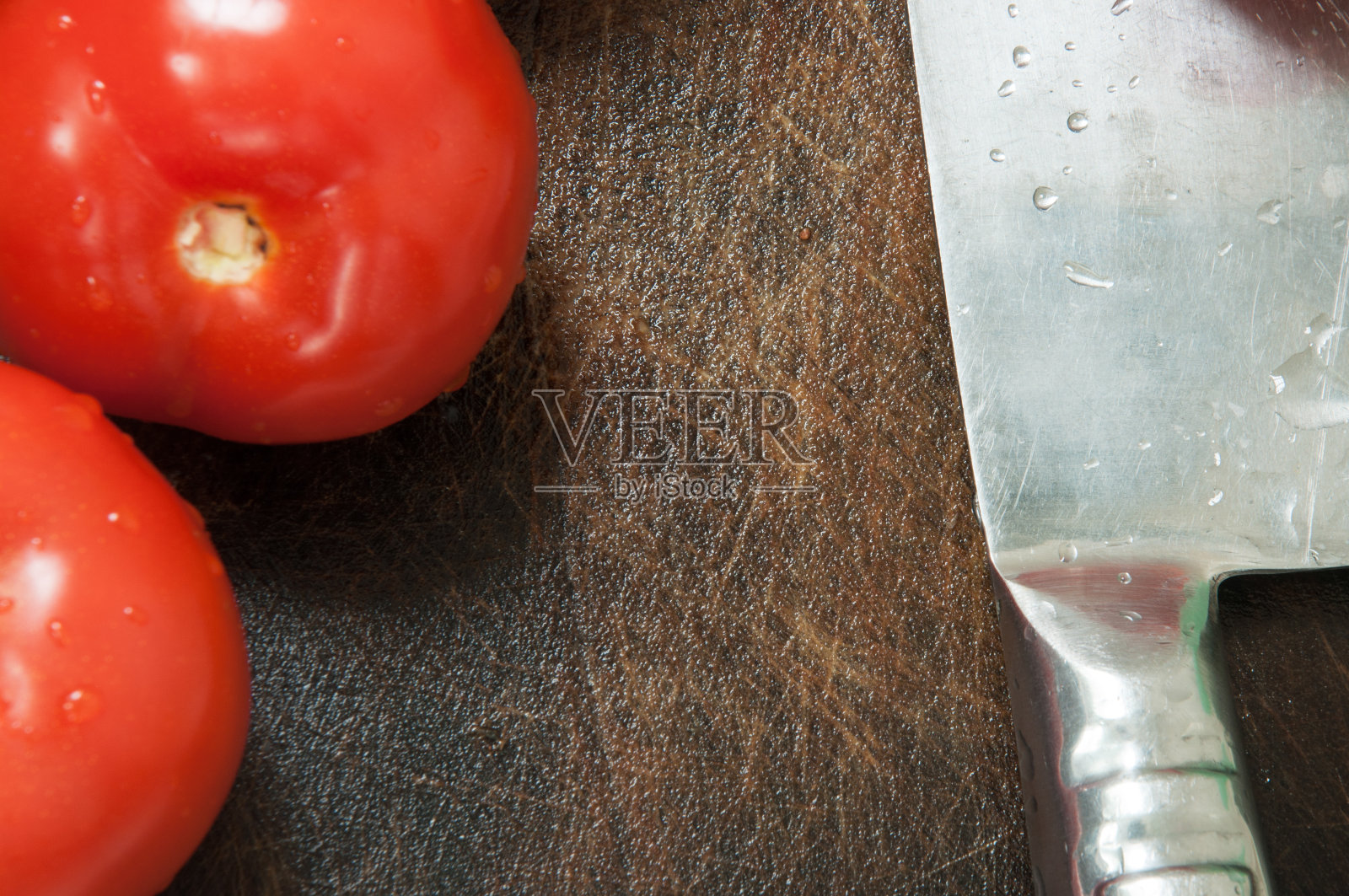 食品的背景。菜刀和番茄放在砧板上。照片摄影图片