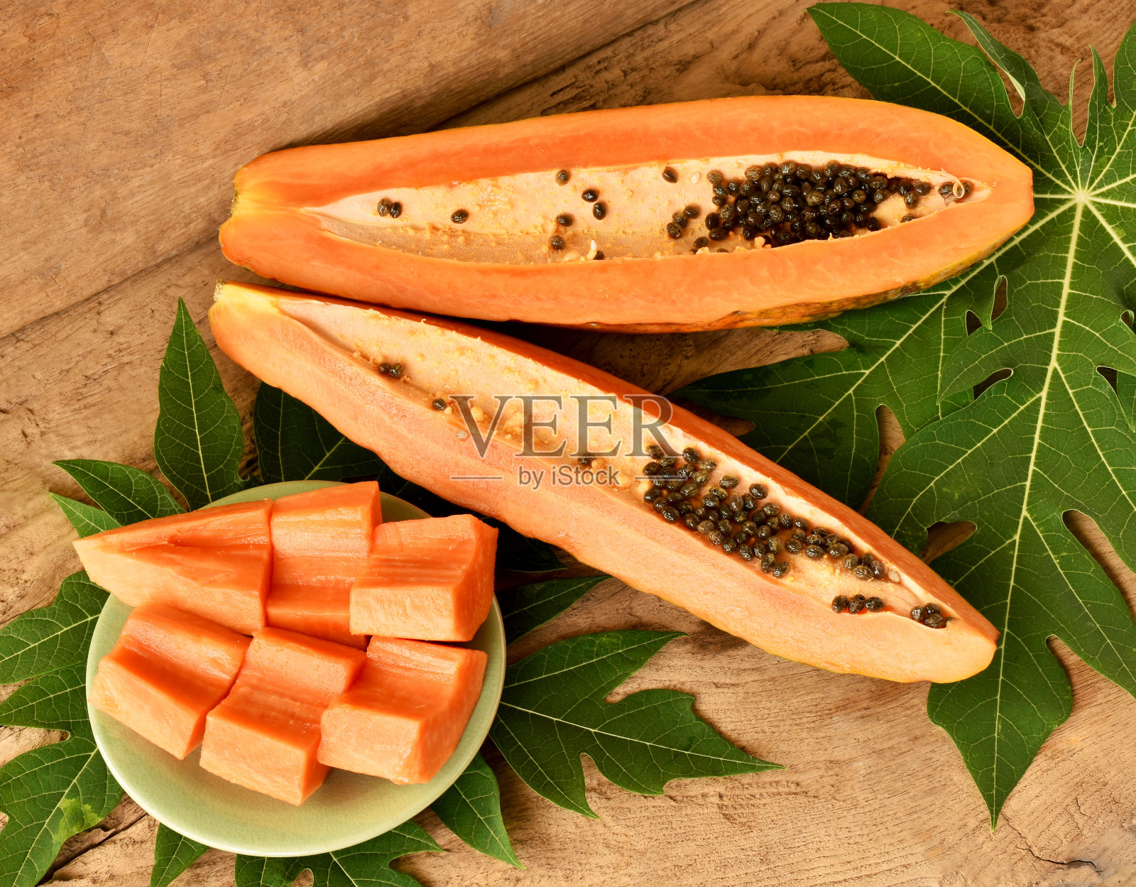 一段甜木瓜和一盘切片。照片摄影图片