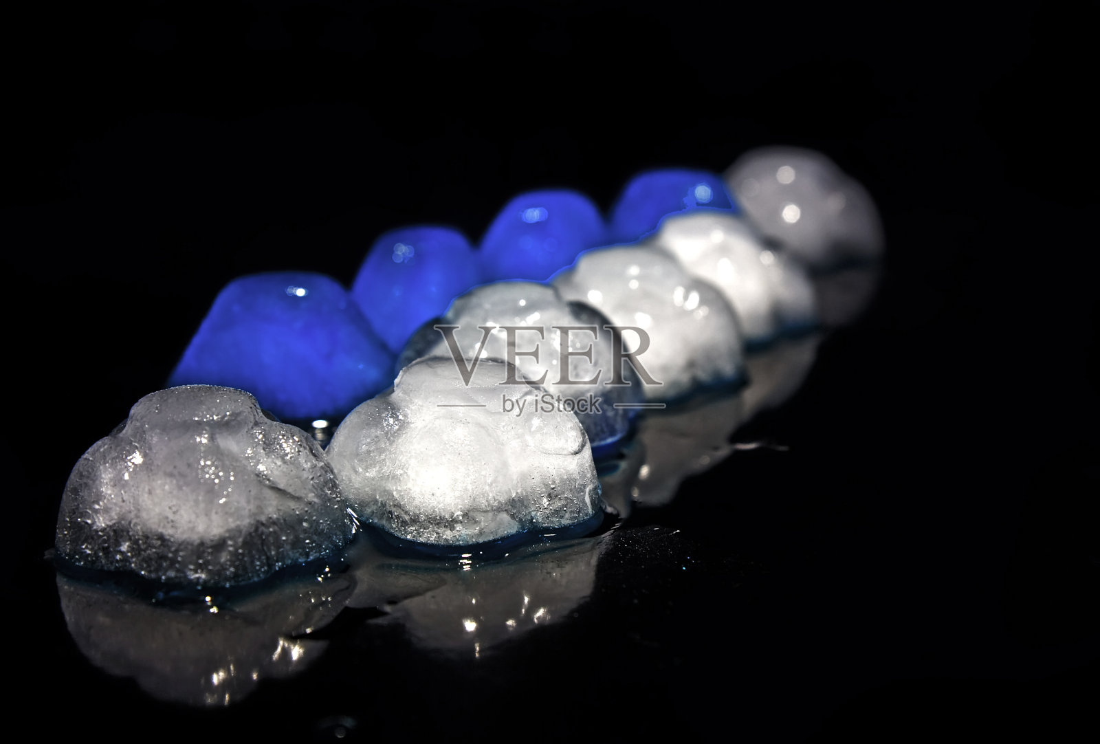 蓝色和白色的冰，在黑色的上面。照片摄影图片