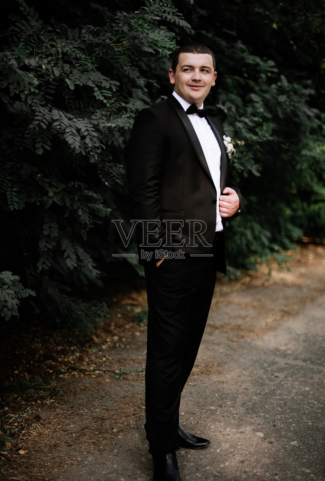 结婚的那一天。新郎穿着黑色经典服饰待着照片摄影图片