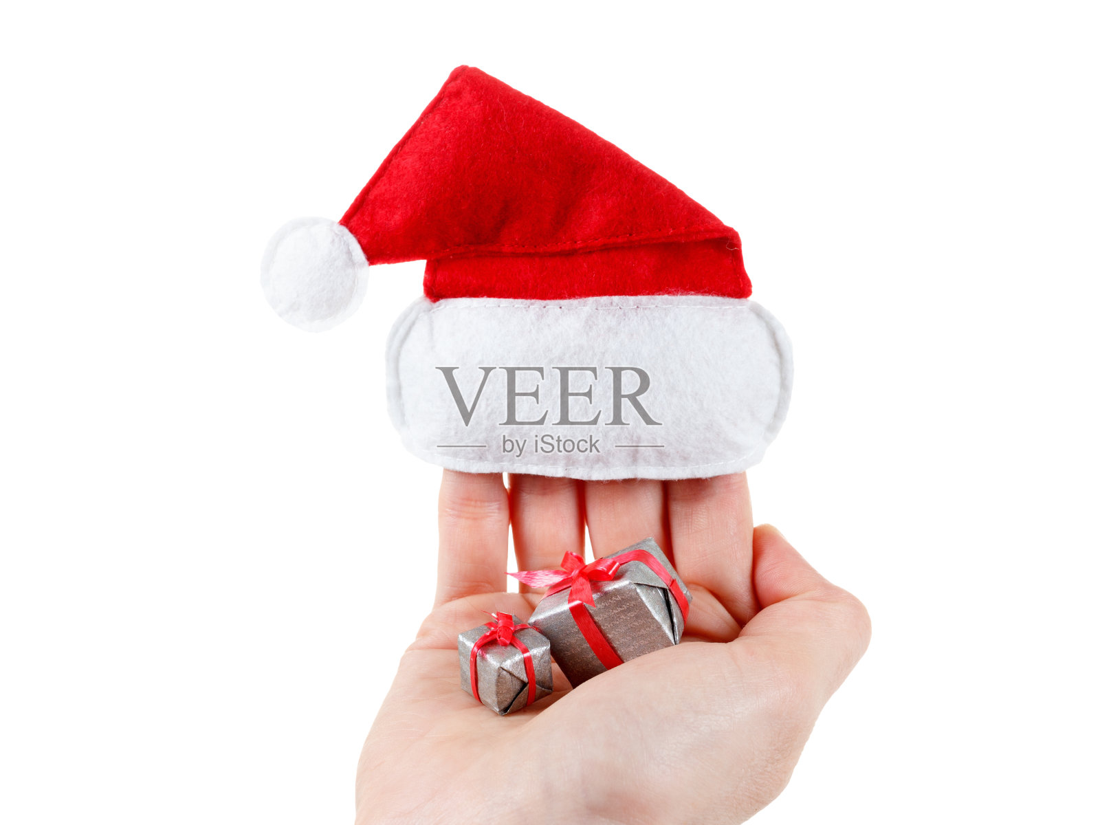 可爱的女性手拿着圣诞老人帽和礼物照片摄影图片