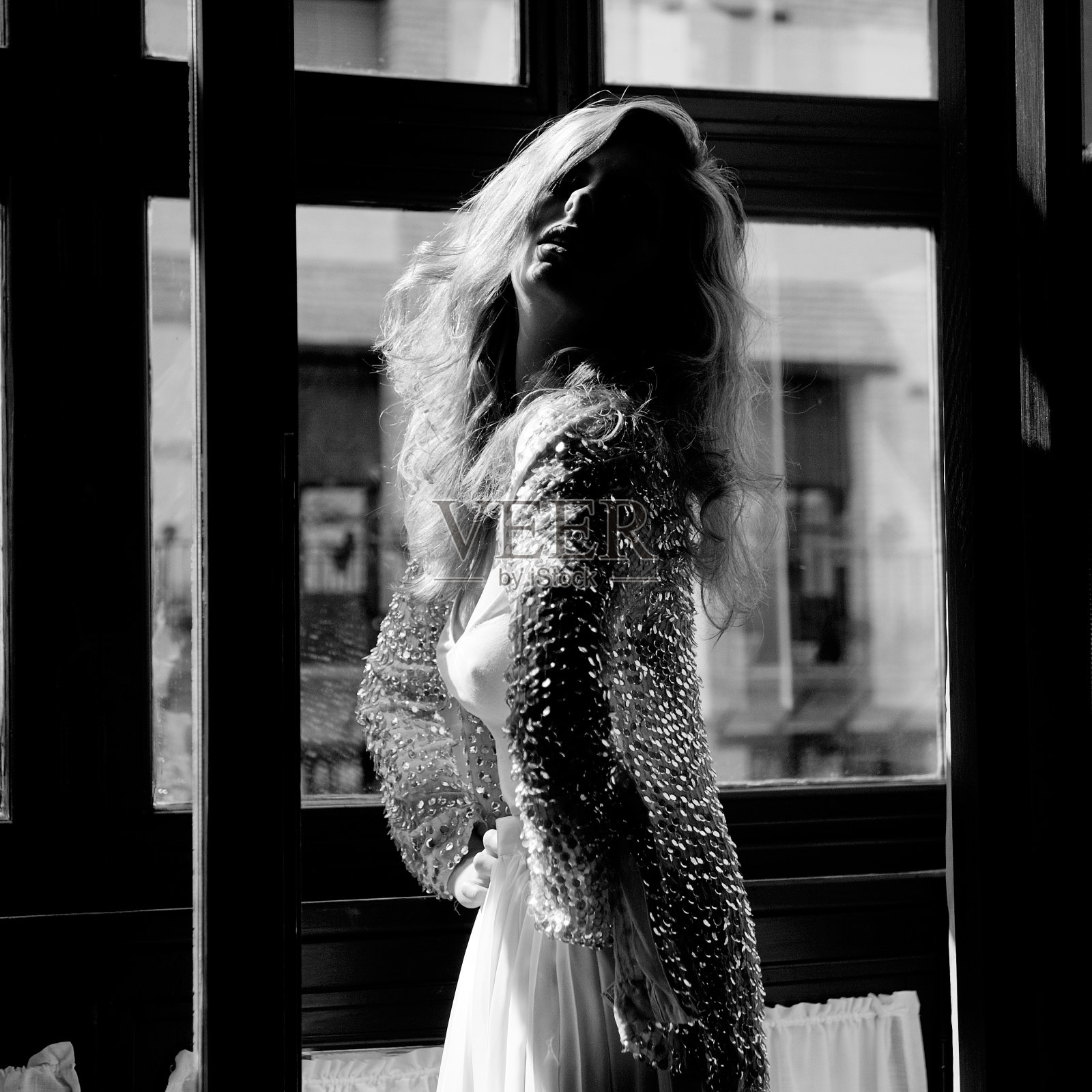 性感的金发女人在窗口，黑白照片照片摄影图片