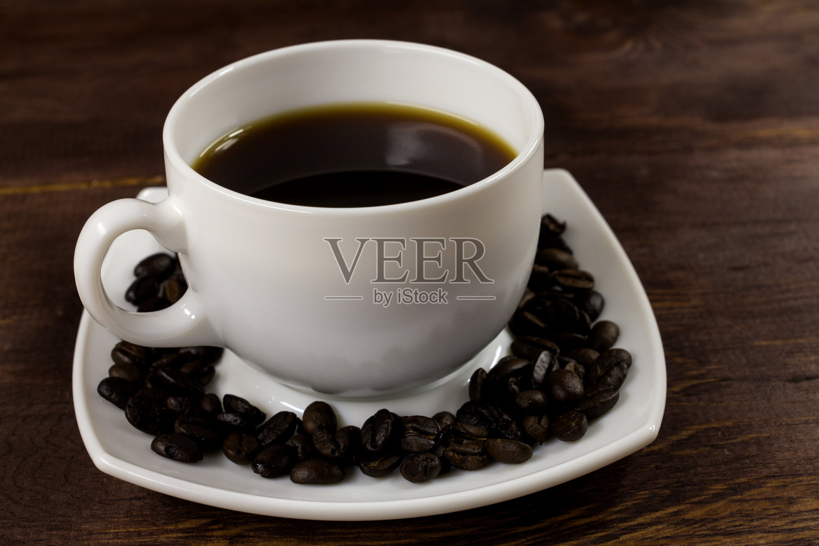 用盘子盛着一杯咖啡和咖啡豆照片摄影图片