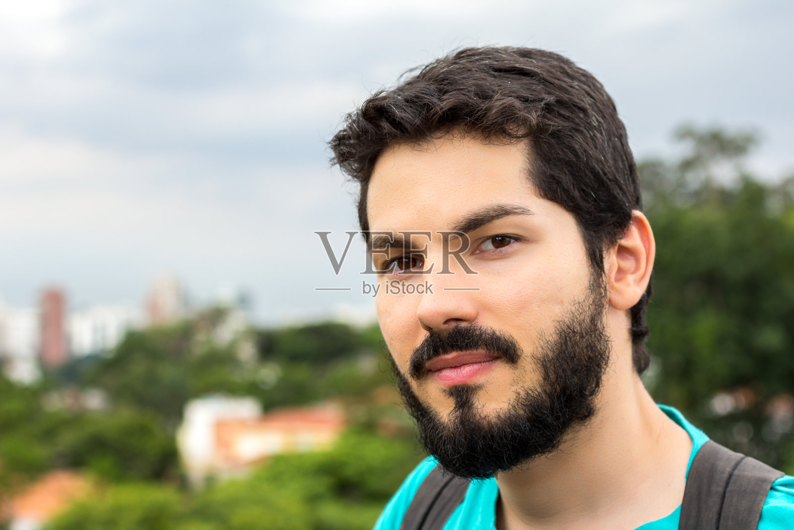 一个留着胡子的年轻人看着照相机照片摄影图片