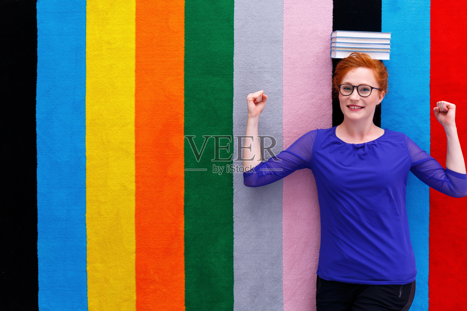 学生躺在她的头上，书照片摄影图片