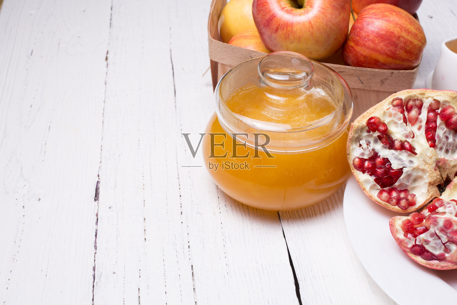 将成熟的石榴、蜂蜜、苹果切块照片摄影图片