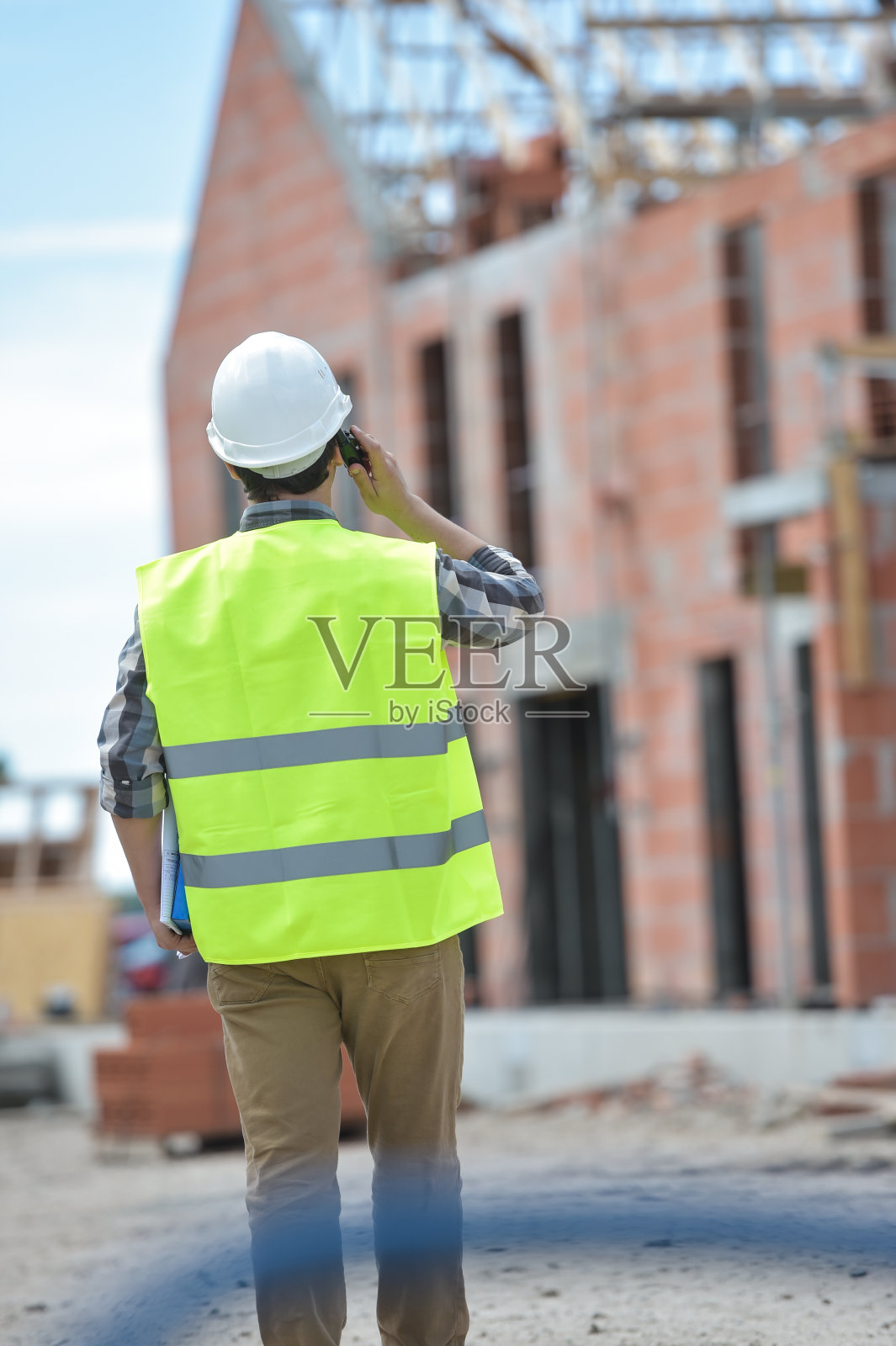 工头用对讲机在工地上走动照片摄影图片