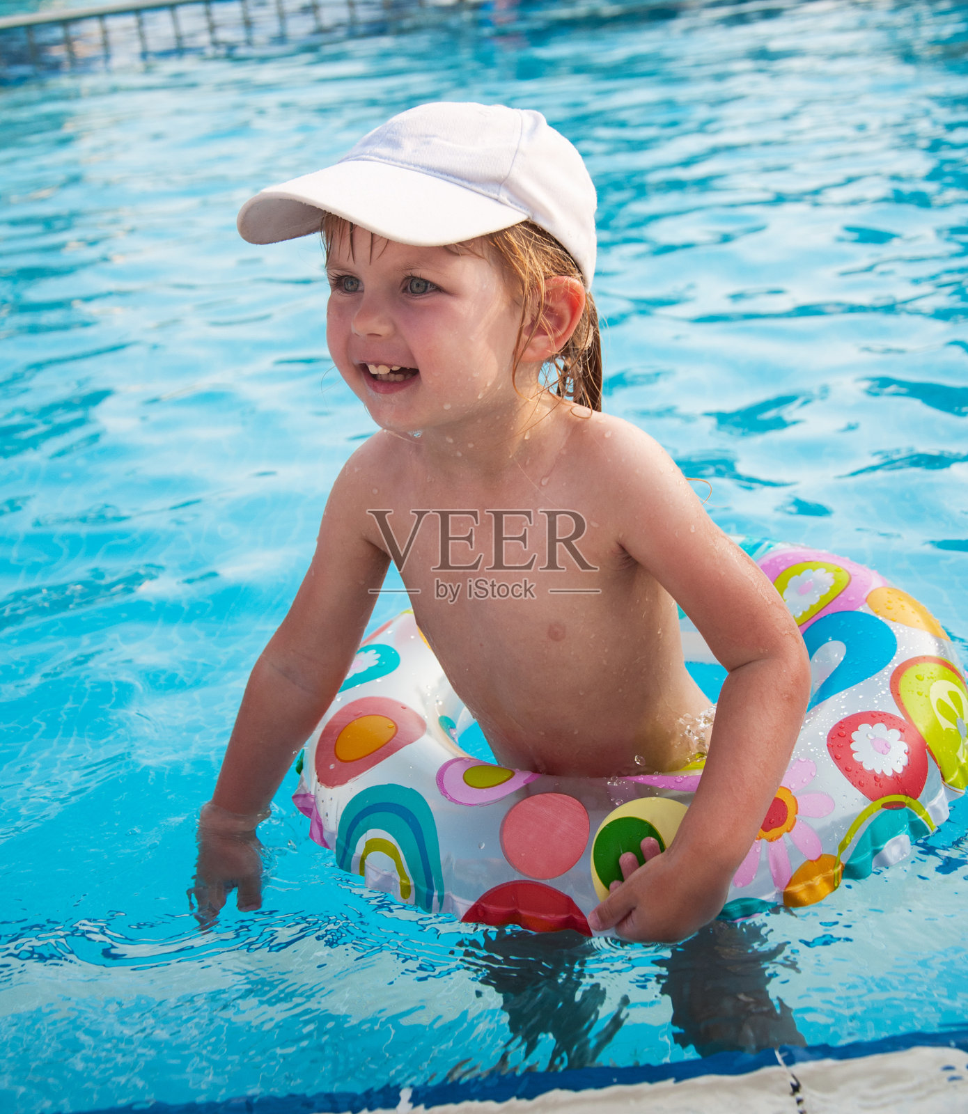 小女孩在游泳池里游泳照片摄影图片