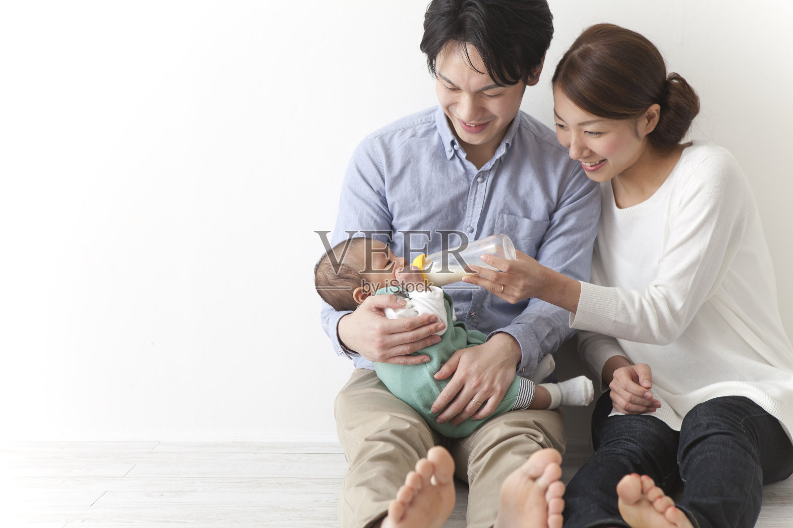 日本夫妇给婴儿喂奶照片摄影图片