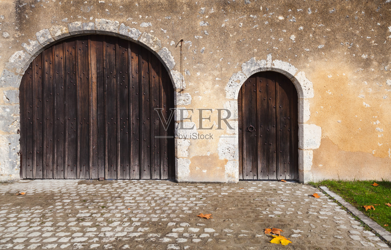 旧石墙上的深色木门照片摄影图片