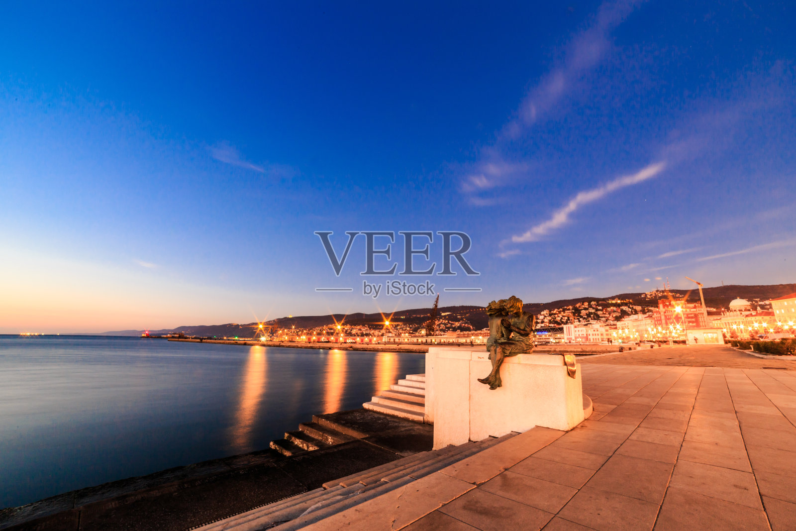 里雅斯特市前的日落照片摄影图片