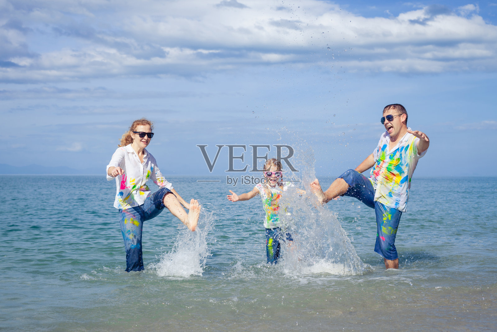 快乐的一家人白天在海滩上玩耍。照片摄影图片