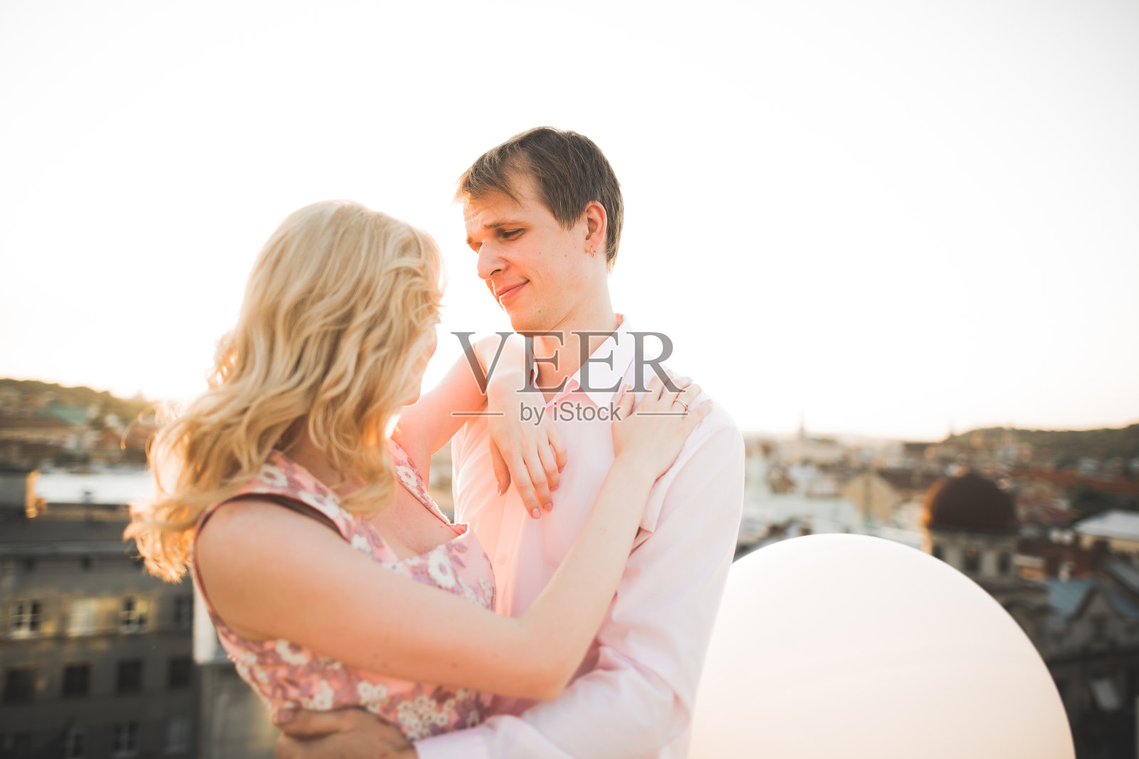 年轻夫妇在完美的城市的屋顶上摆姿势照片摄影图片