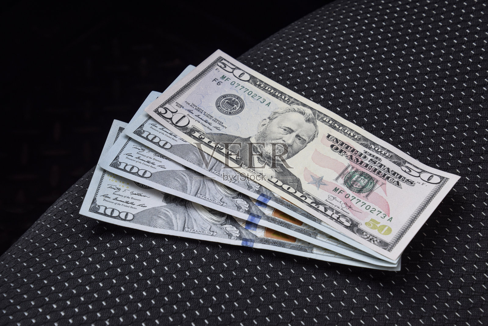 汽车安全座椅上放着几张钞票和美元照片摄影图片