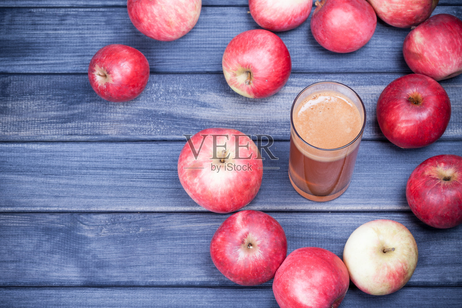 鲜榨苹果汁装在深色木制玻璃杯里照片摄影图片