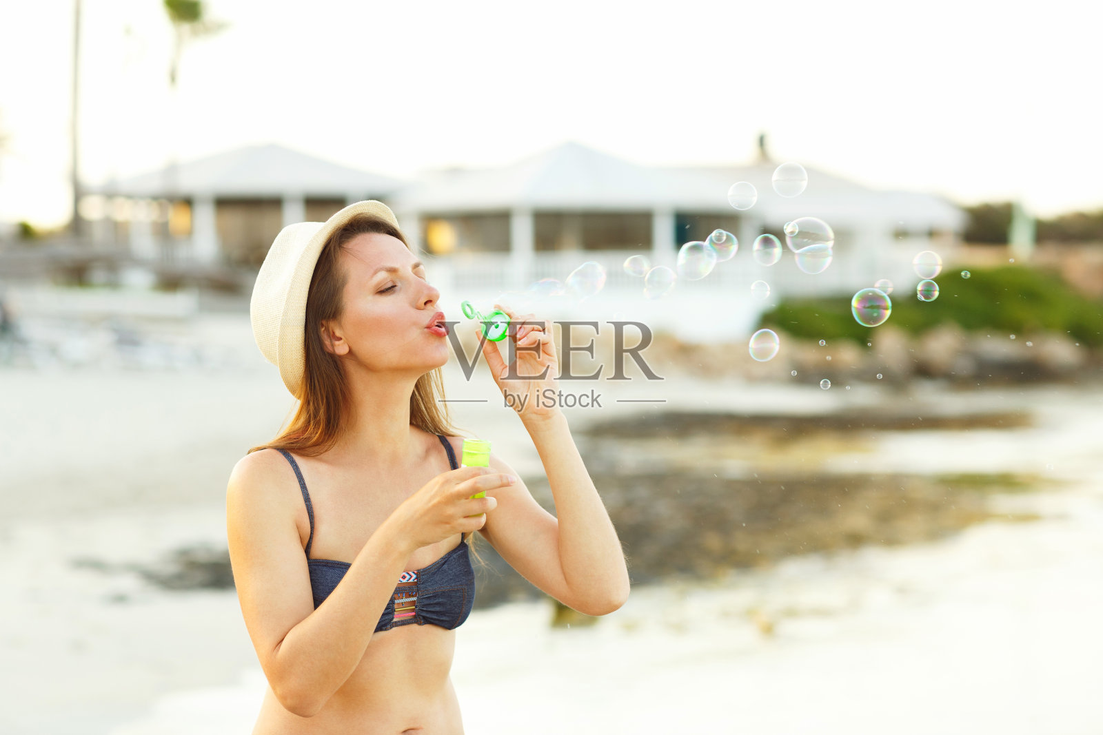 年轻女子在海边吹肥皂泡照片摄影图片