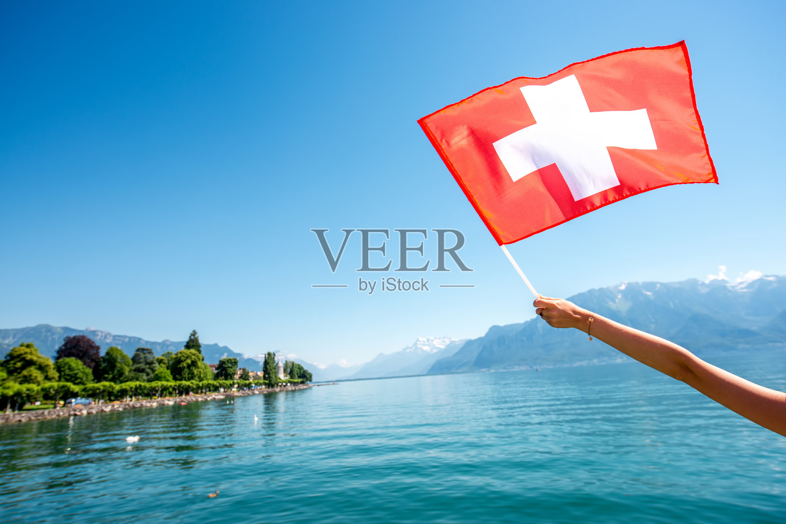 瑞士国旗在湖的背景照片摄影图片