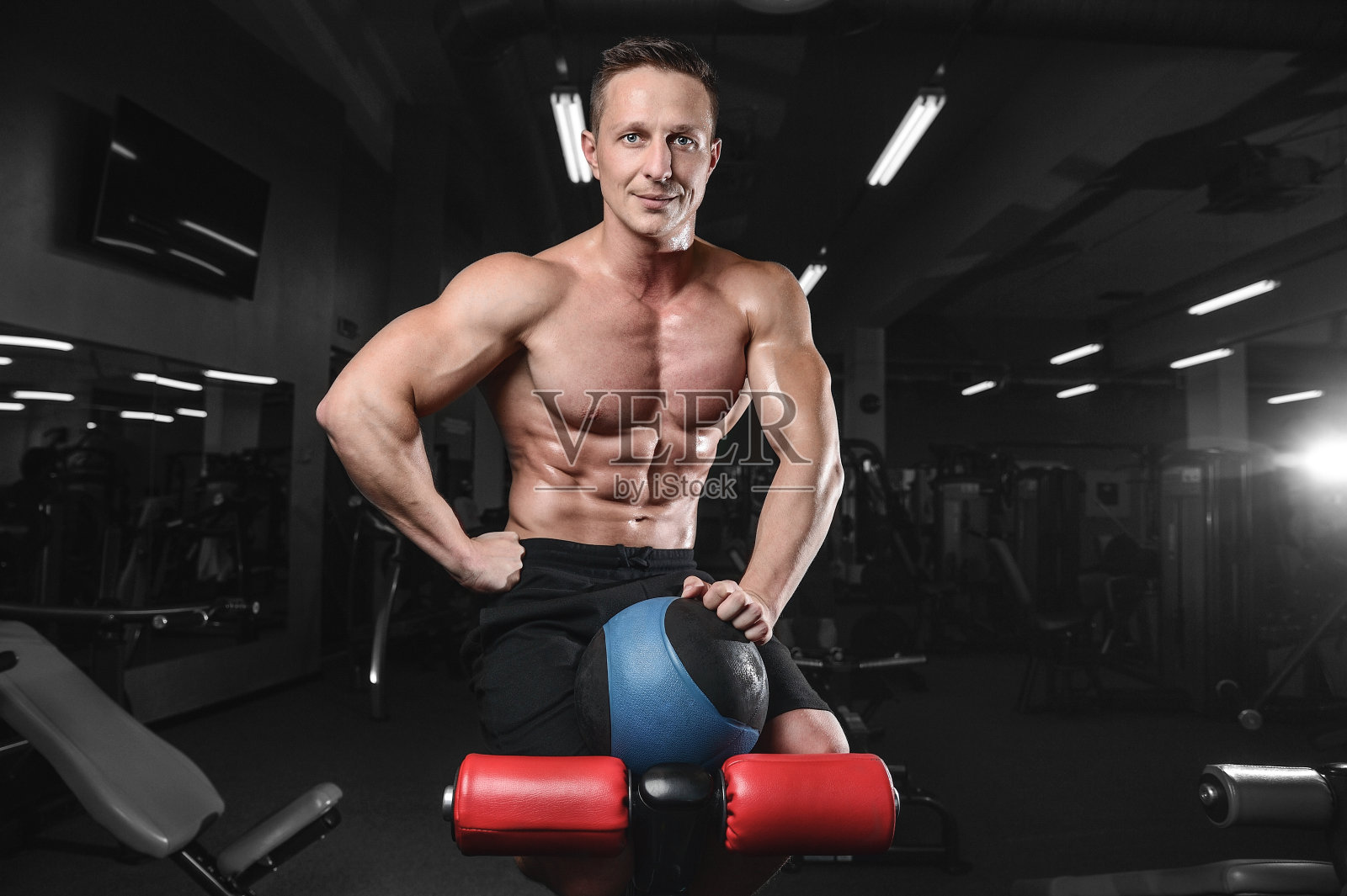 英俊的运动员健身男子摆姿势和训练在健身房照片摄影图片