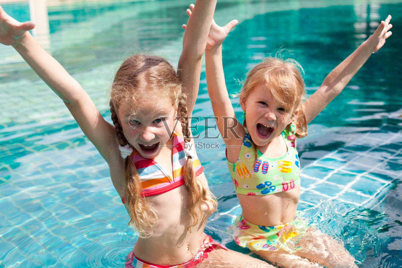 两个小女孩在游泳池里玩照片摄影图片