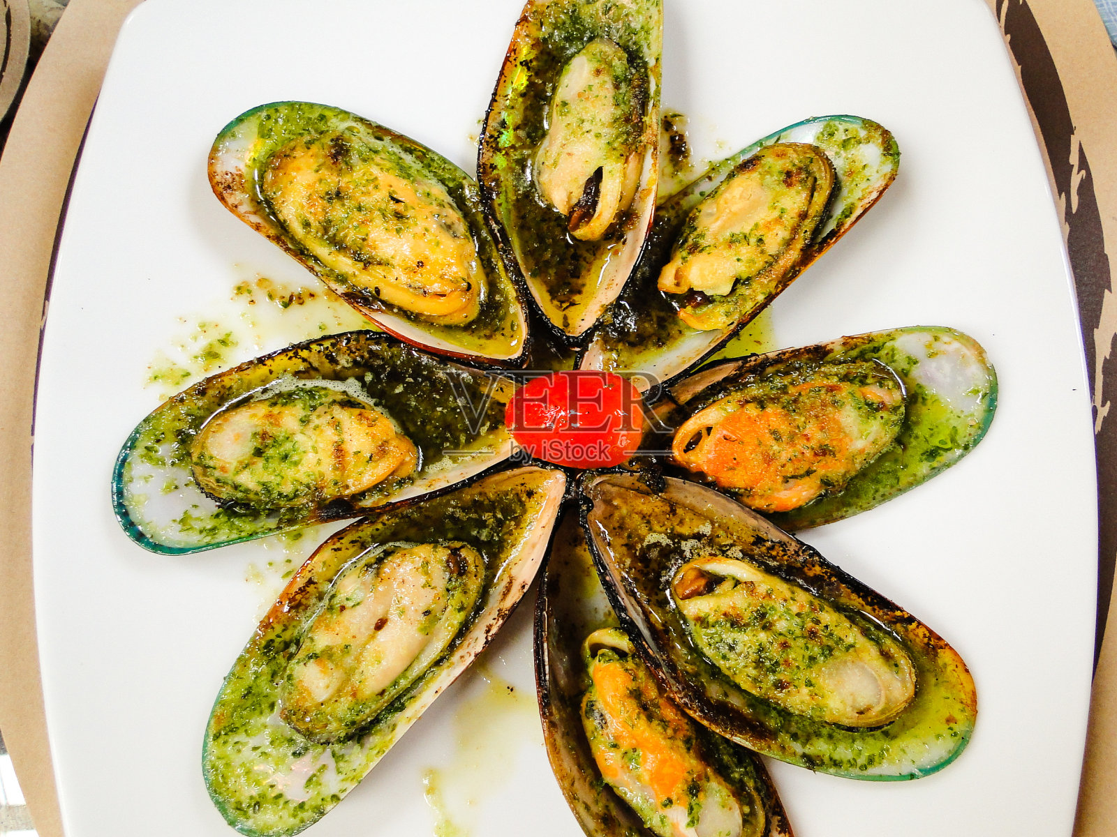 加蒜蓉黄油的贻贝，盛在白色盘子里照片摄影图片