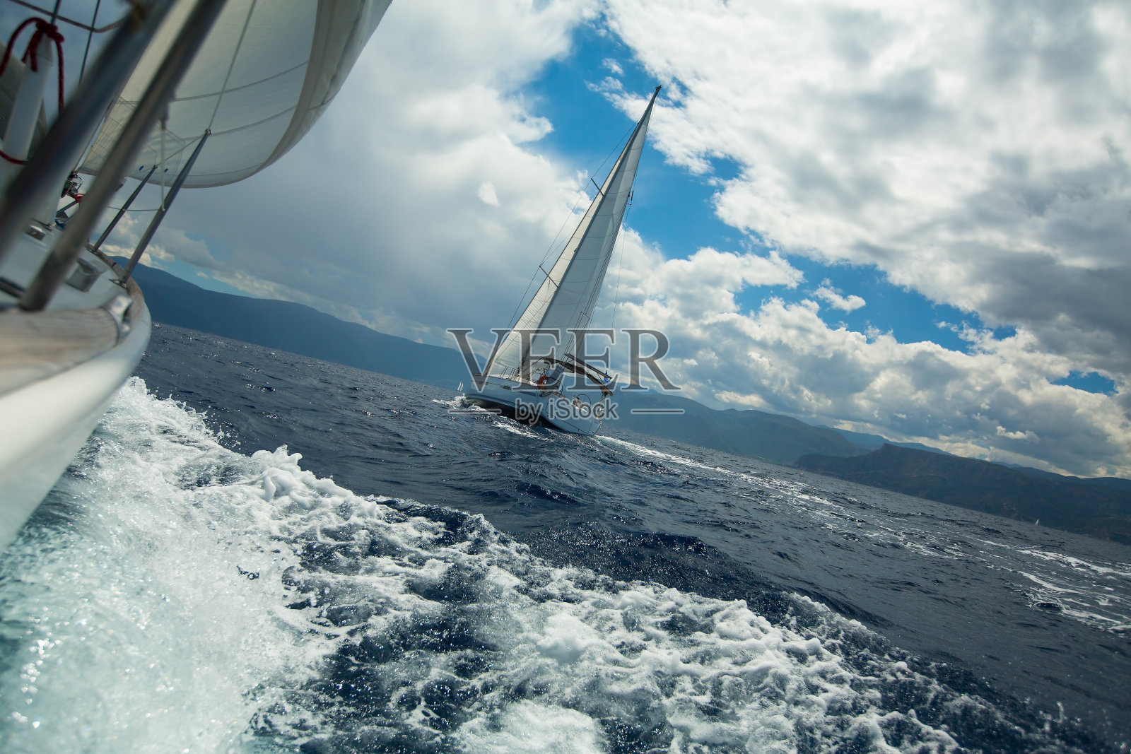 在暴风雨中航行在海浪上。照片摄影图片