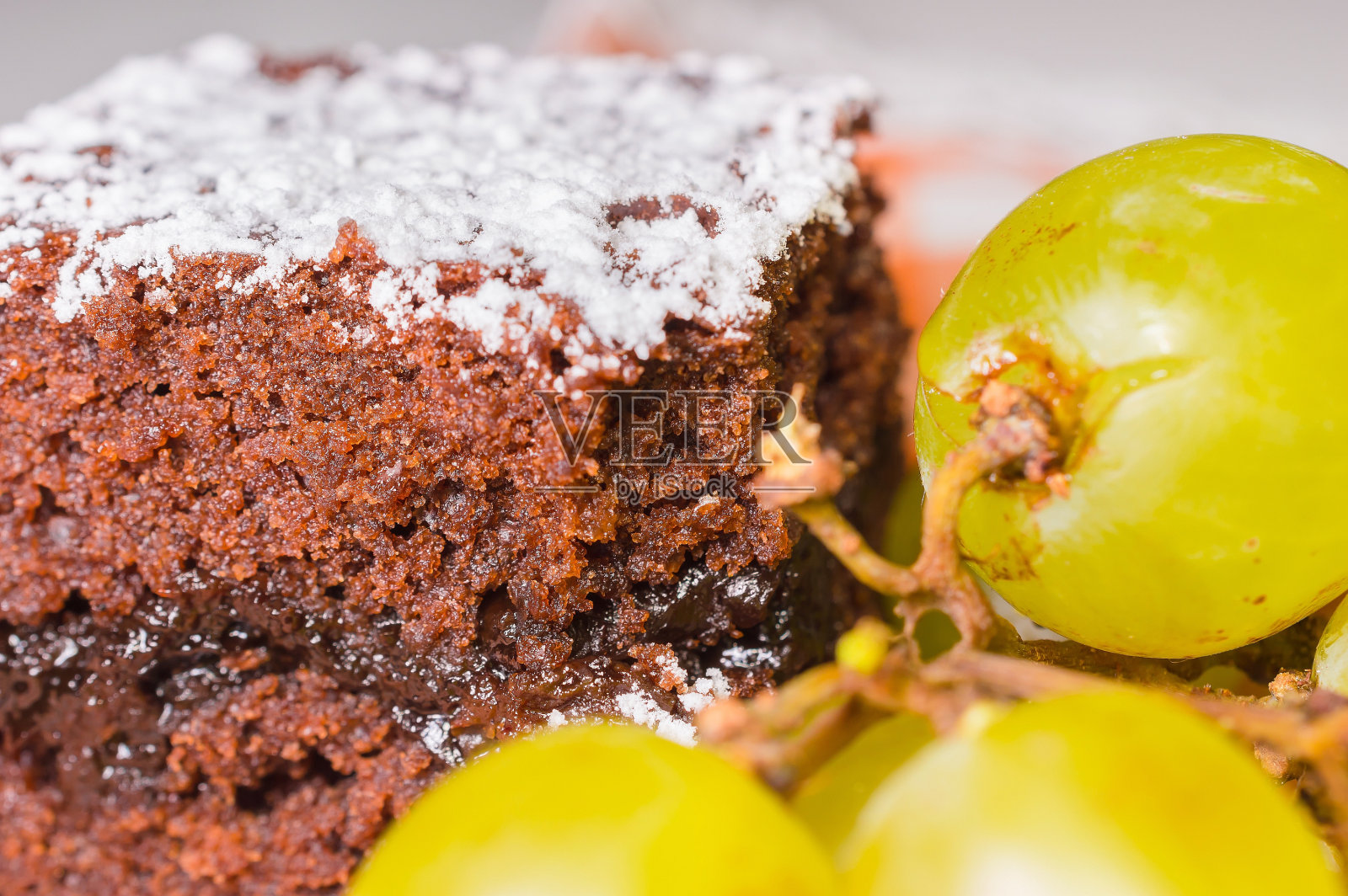 巧克力海绵蛋糕上有糖霜和葡萄照片摄影图片